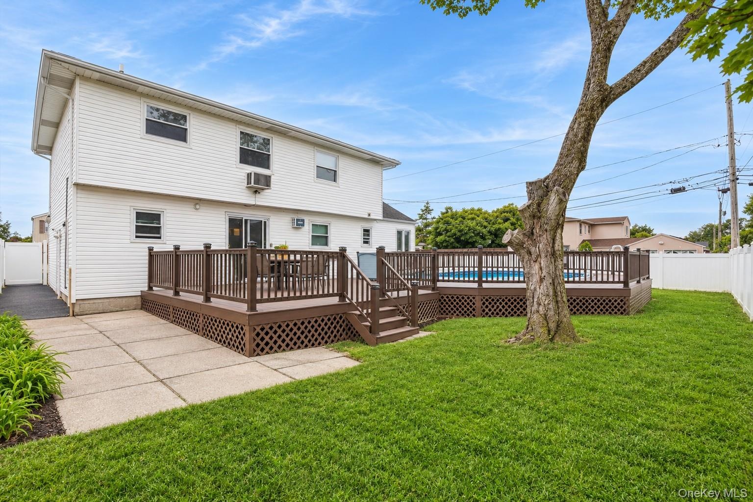 Yard spaces around permitted partially inground pool with fence and trek decking surrounding (virtually enhanced)