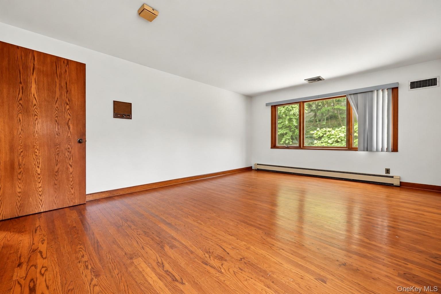 BR 2.  Oversized windows. Wood floors. Extraneous objects removed from photo.