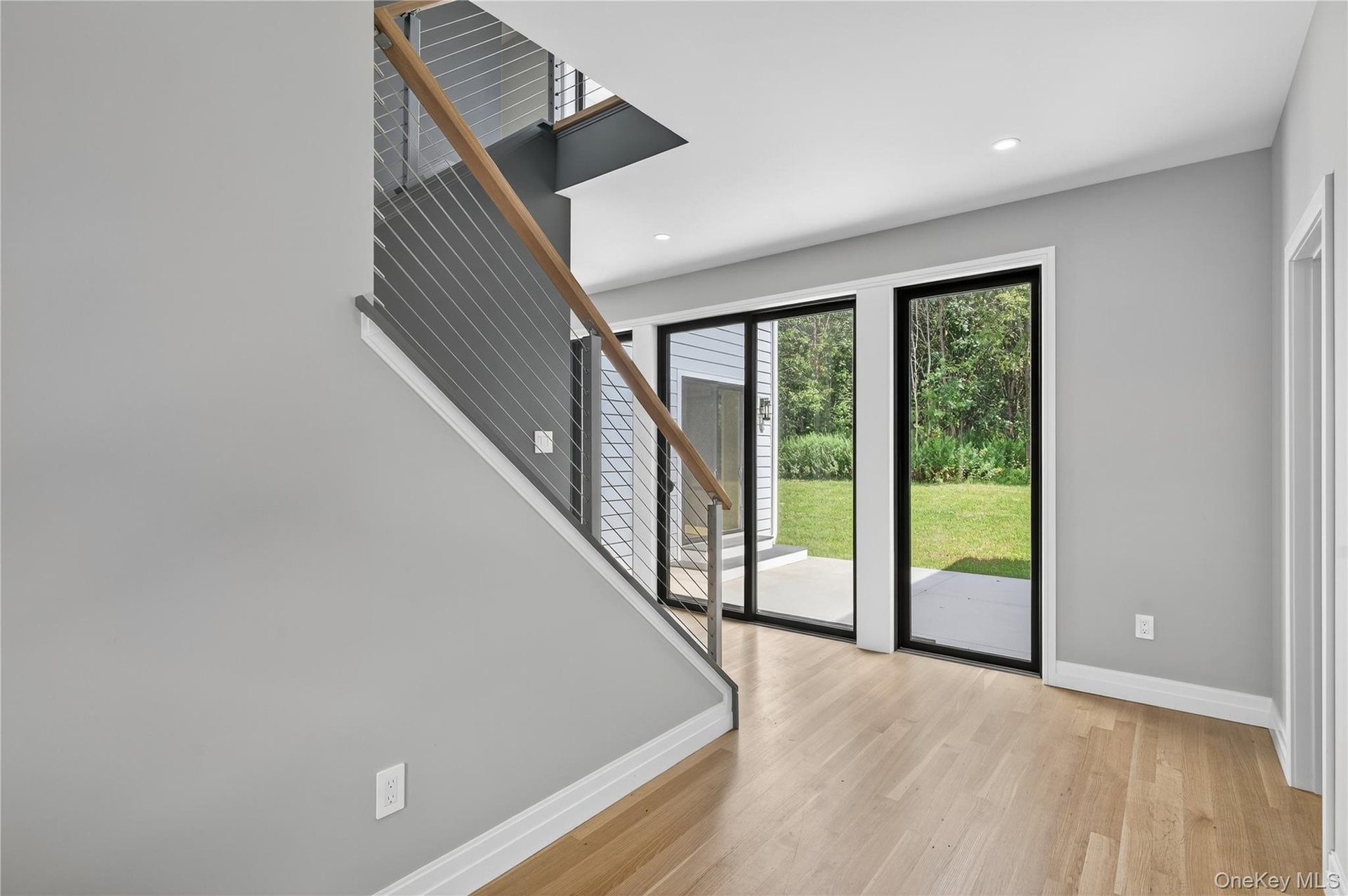 Foyer with light wood-style flooring, stairs, and recessed lighting