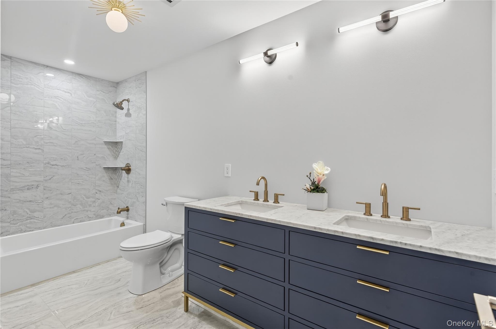 Bathroom with shower / washtub combination, double vanity, and recessed lighting