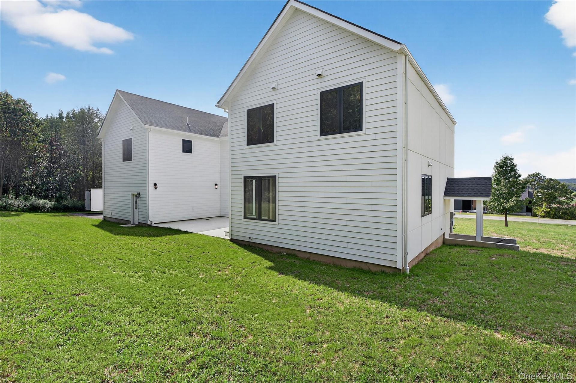 Rear view of house featuring a lawn and a patio