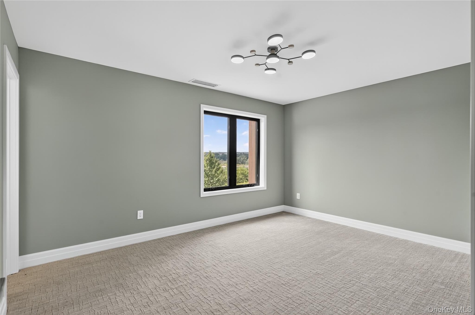 Unfurnished room featuring baseboards and light carpet