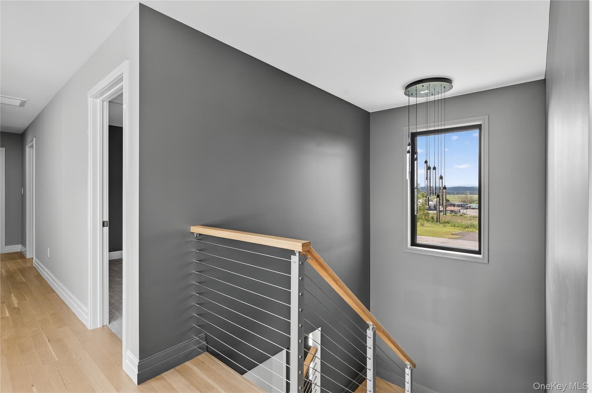 Corridor featuring an upstairs landing and light wood finished floors