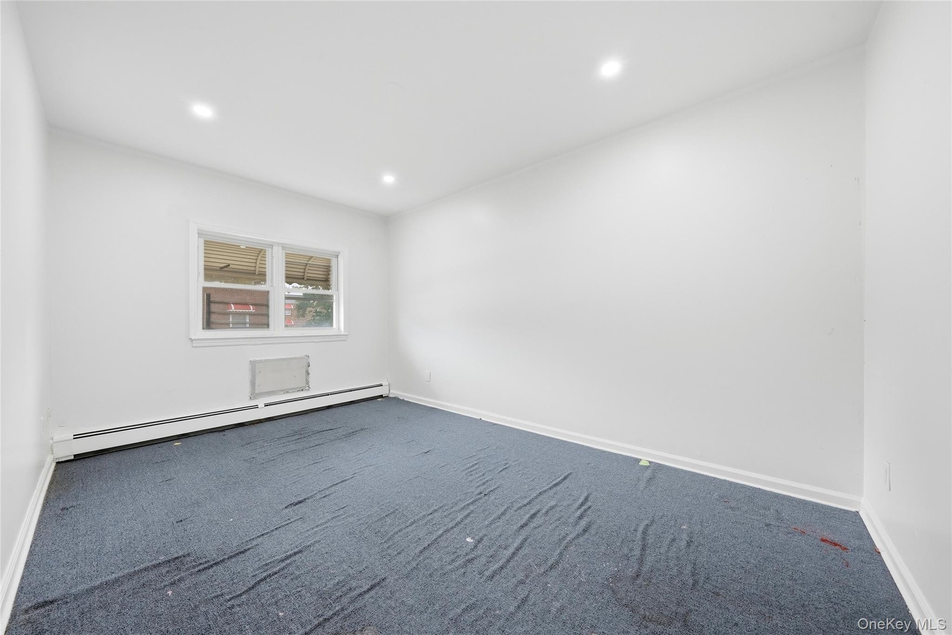 Recessed lighting, window with white trim, baseboard heating, and wall-to-wall carpeting