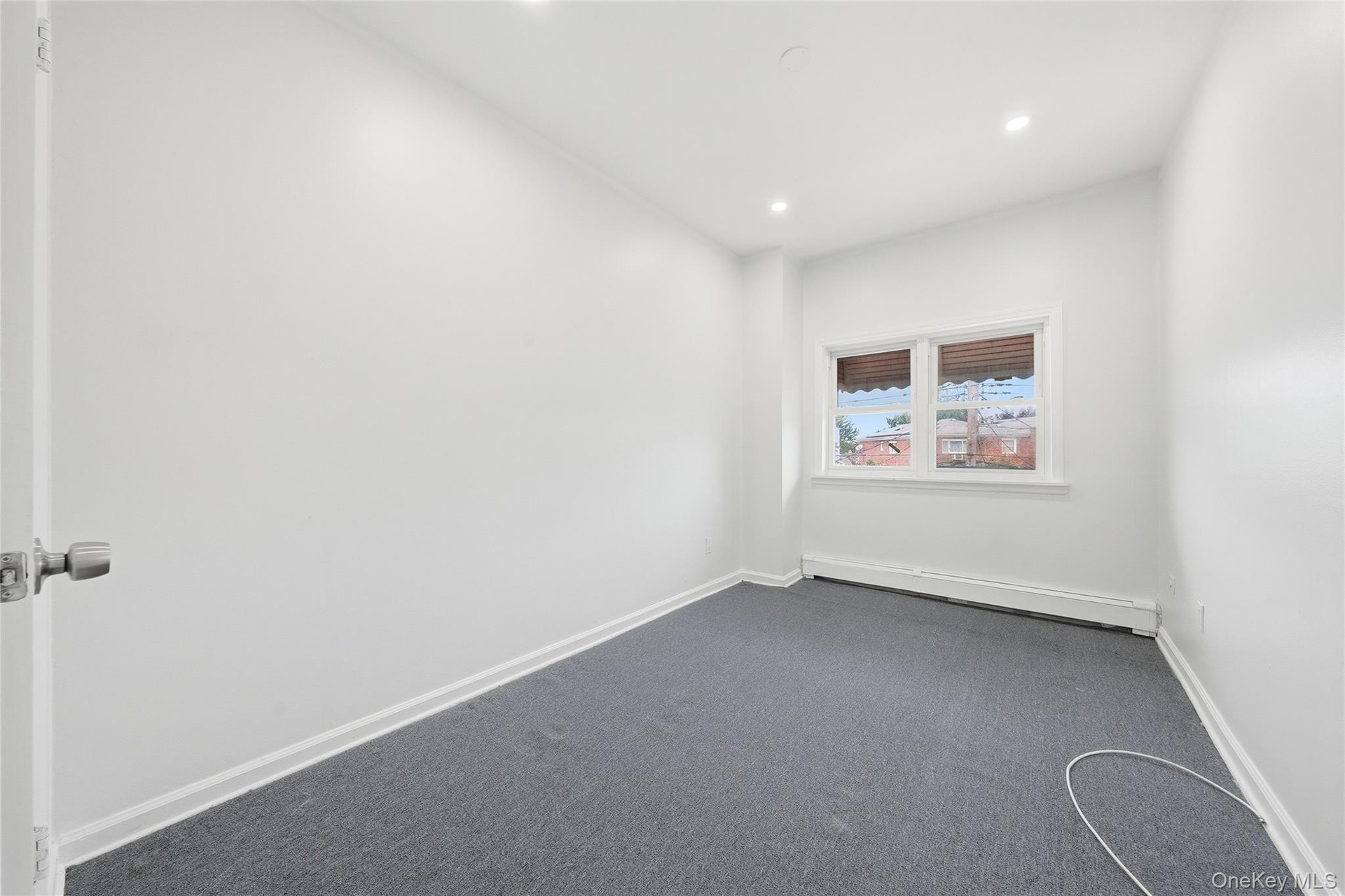 Recessed ceiling lighting, white painted walls, gray carpeting, and window with blinds
