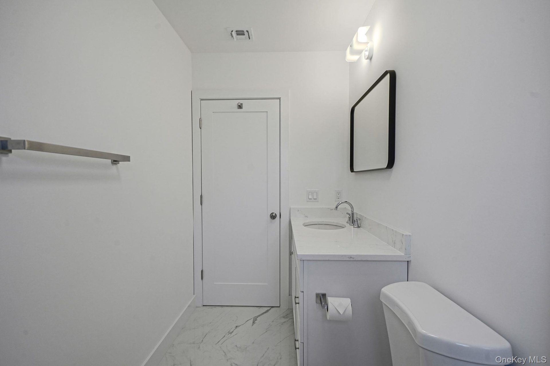 Bathroom with marble finish floors, vanity, toilet, and baseboards