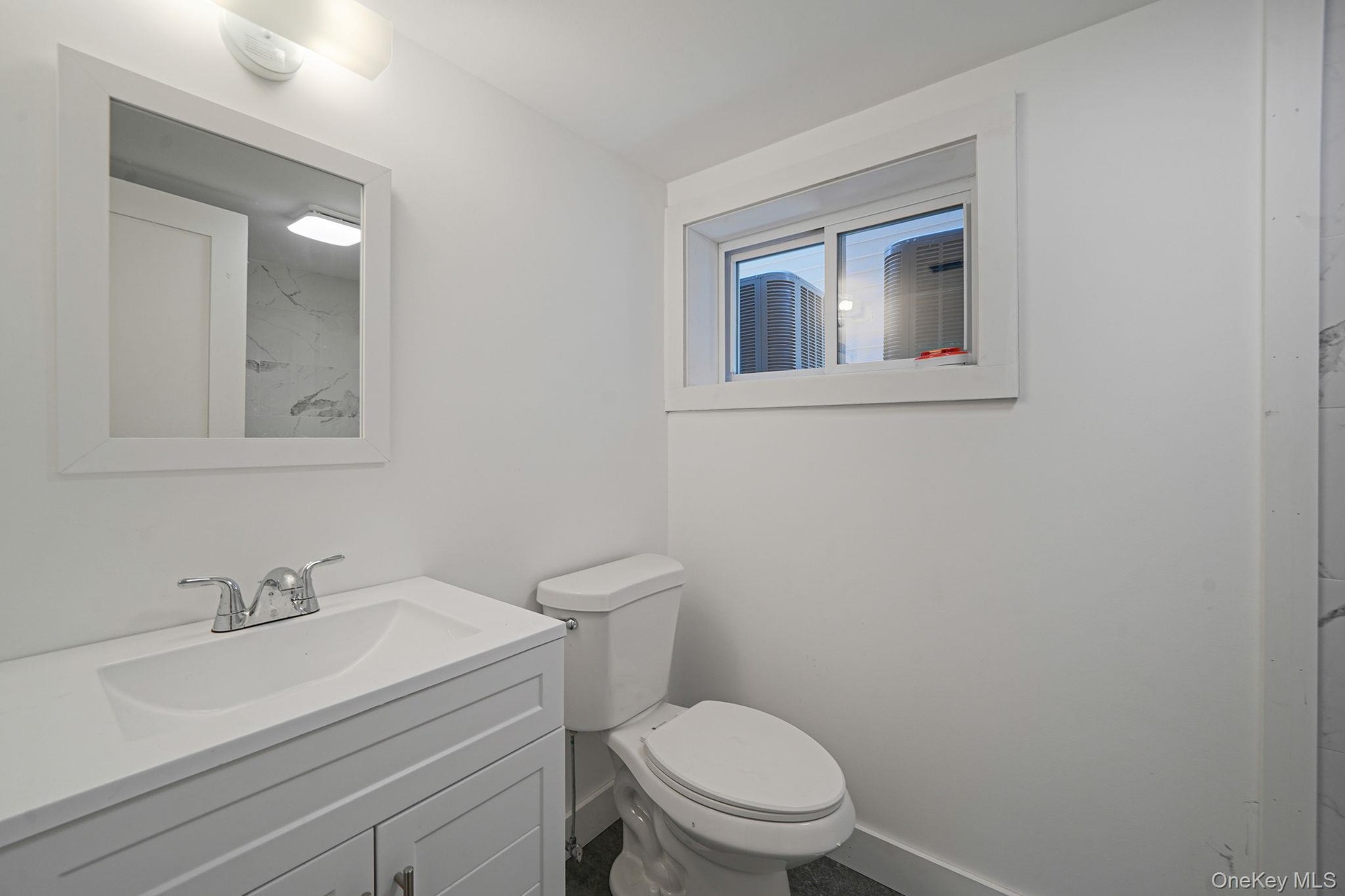 Bathroom with vanity, toilet, and baseboards
