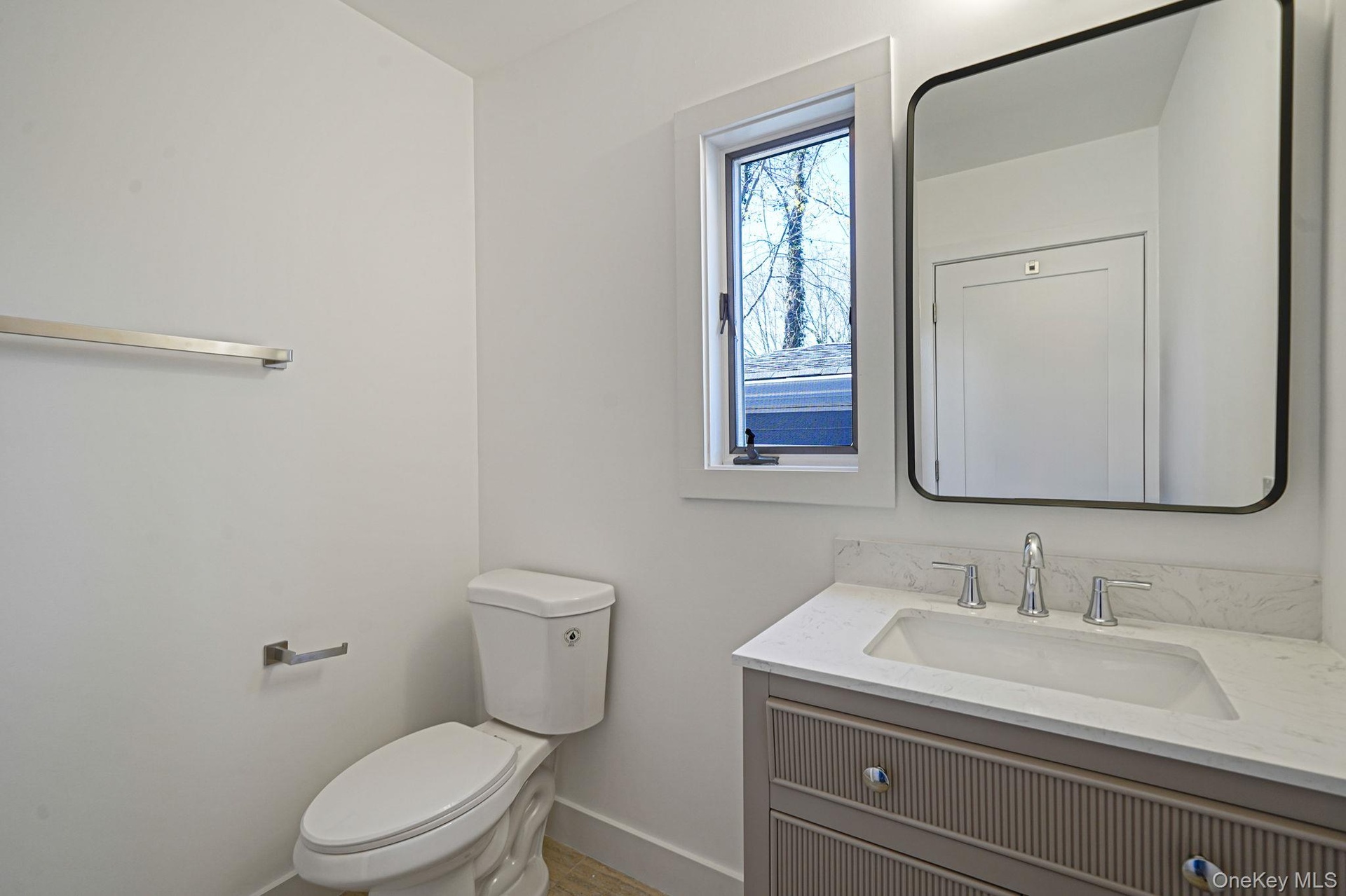 Bathroom featuring vanity, baseboards, and toilet
