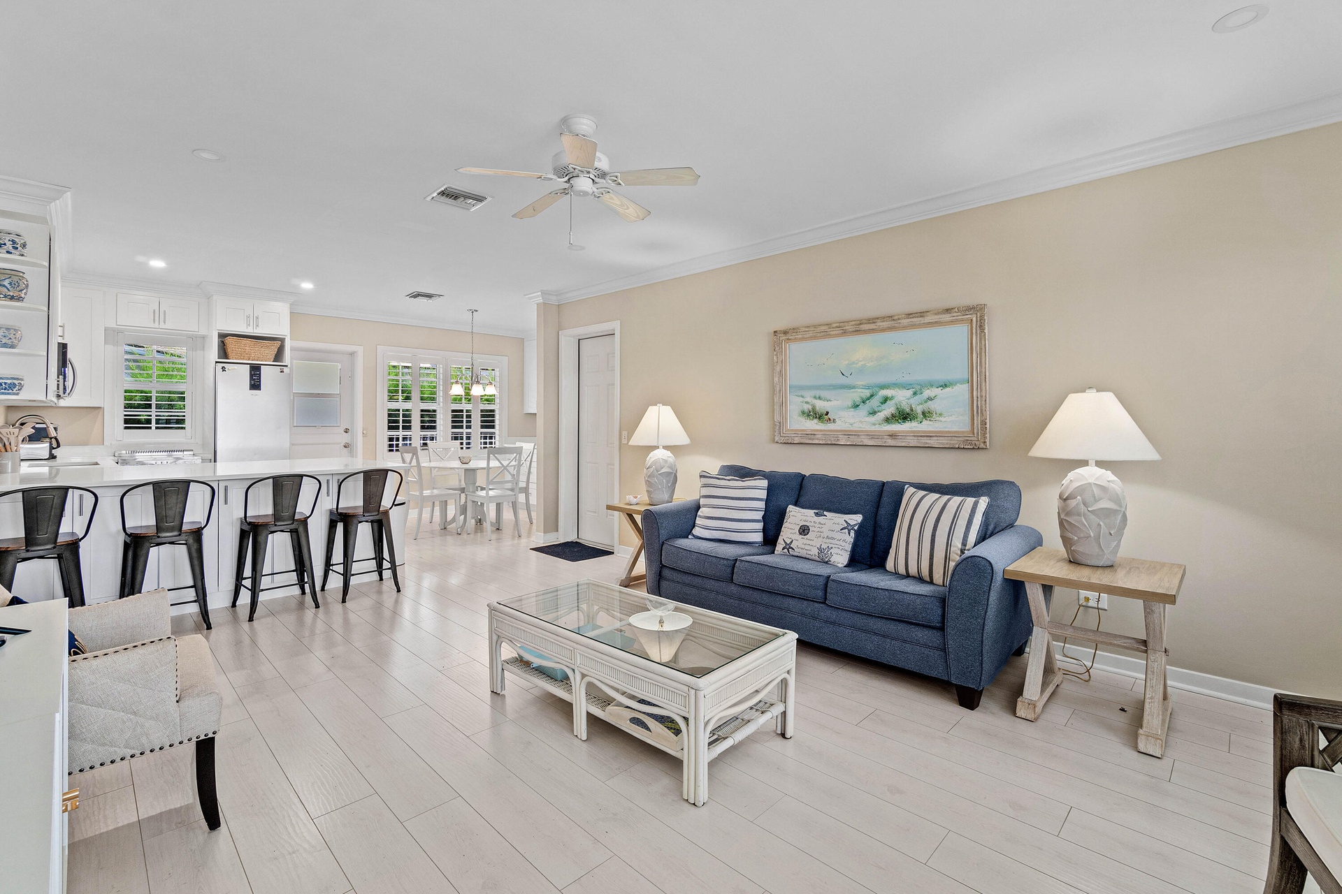 Open concept living area featuring light wood-look flooring, crown molding, a ceiling fan, and recessed lighting