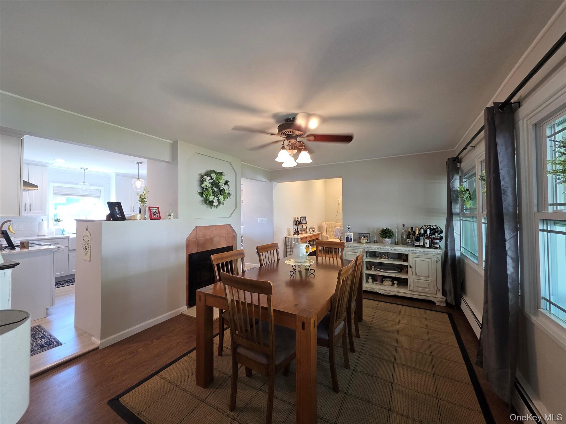 Dining Room with  a wood burning fireplace, ceiling fan & LVT Floor