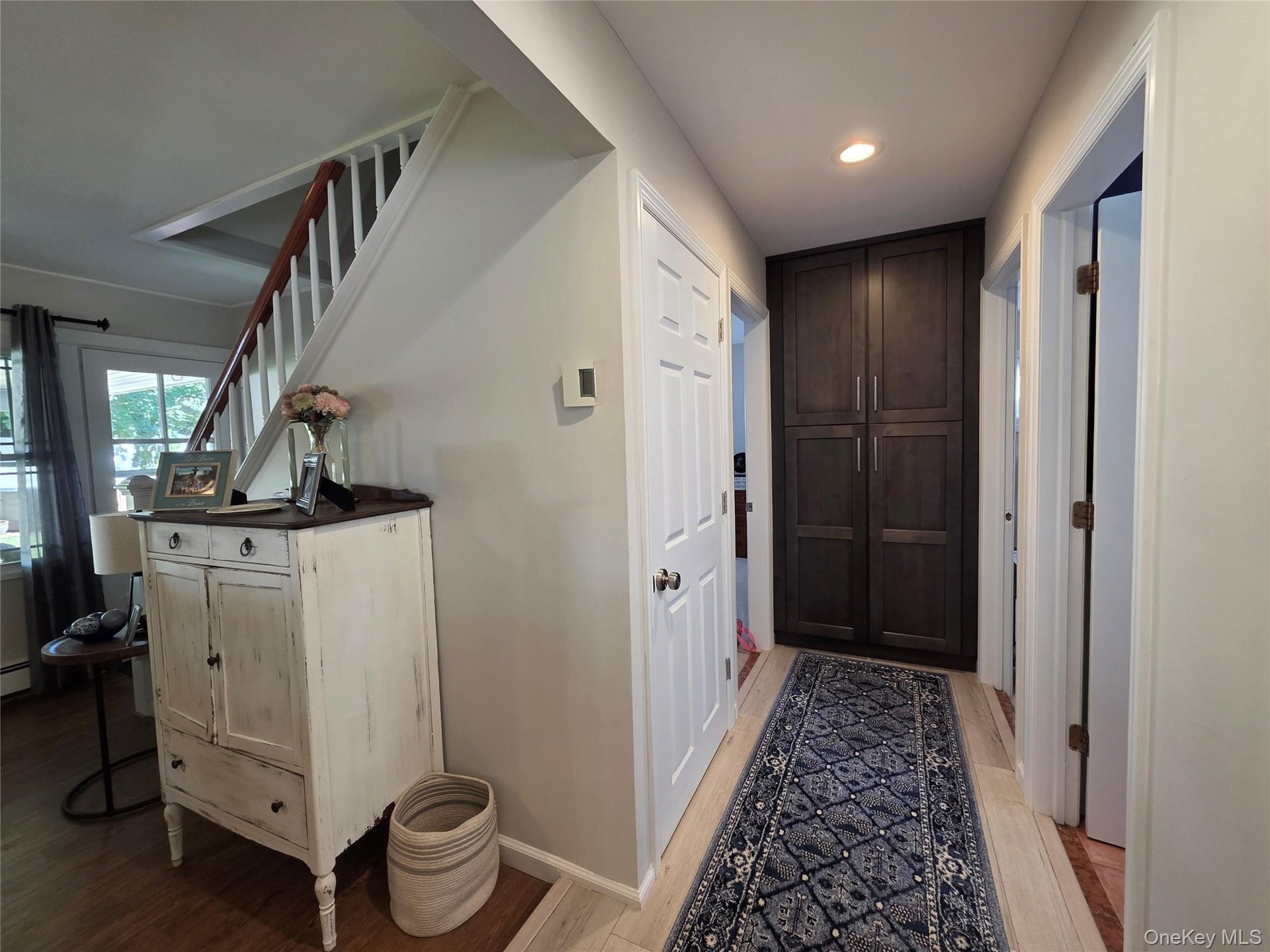 A hallway loaded with storage areas! Deep Closet underneath stairs, and a large pantry with custom cabinetry!