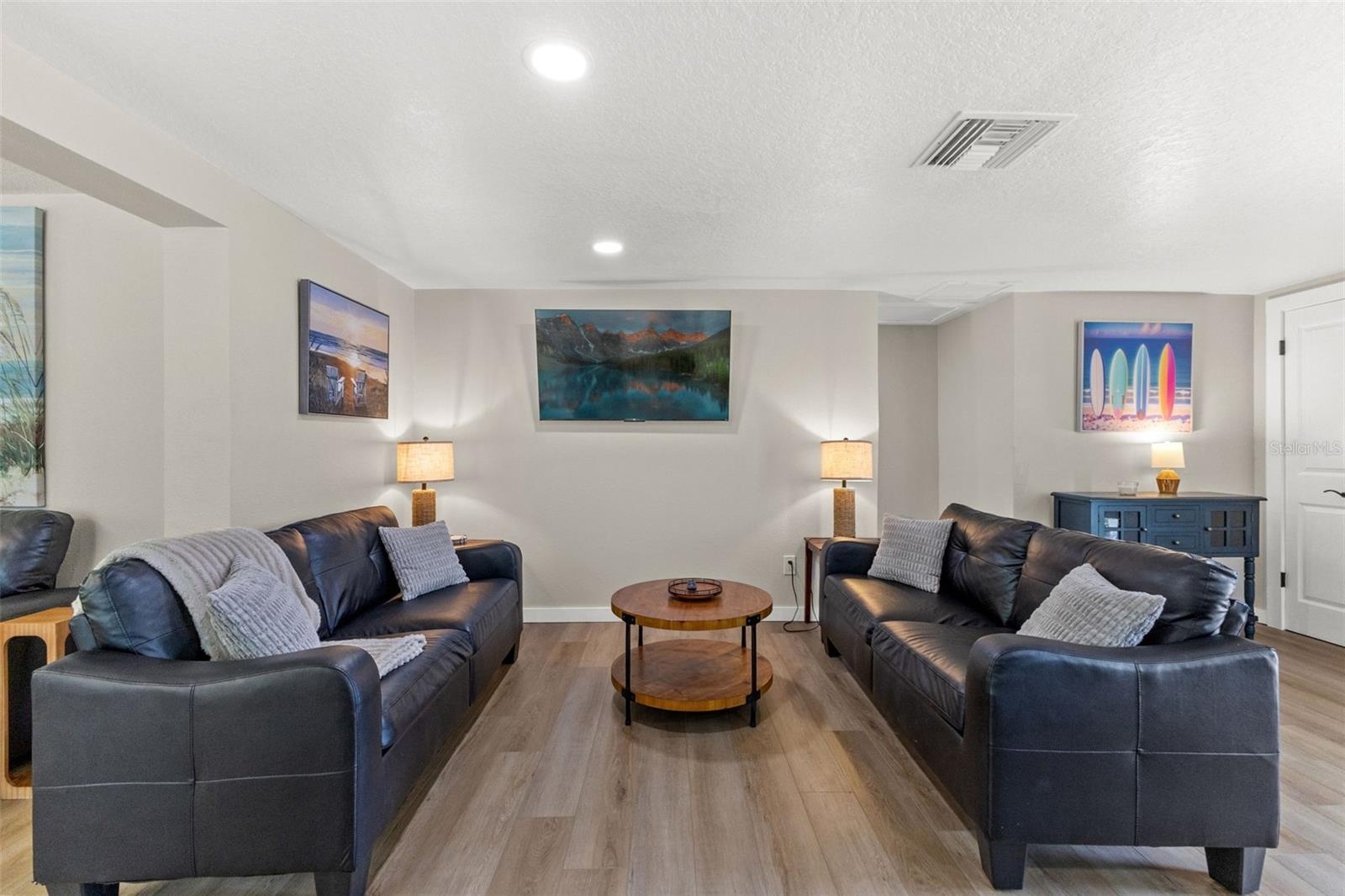 Spacious main living area with luxury vinyl plank flooring and an open layout that connects easily to the kitchen and dining spaces.