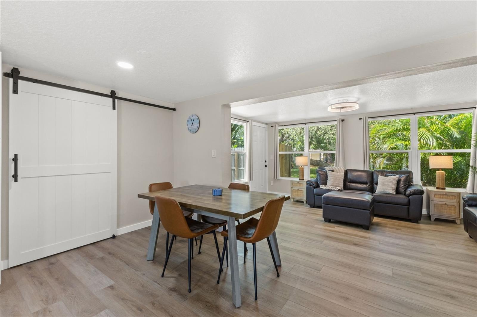 Dedicated dining area sits between the renovated kitchen and living spaces, with a large barn door adding character and function.