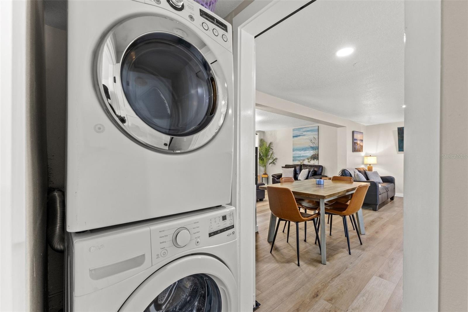 Convenient interior laundry with a full-size stacked washer and dryer just off the main living and dining areas.