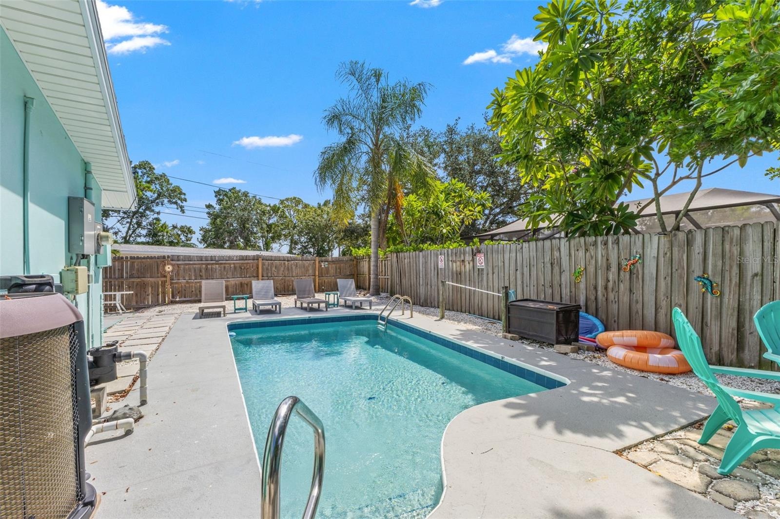 Private heated pool surrounded by multiple areas for lounging and outdoor entertaining, with a new pool pump and heater added in 2025.