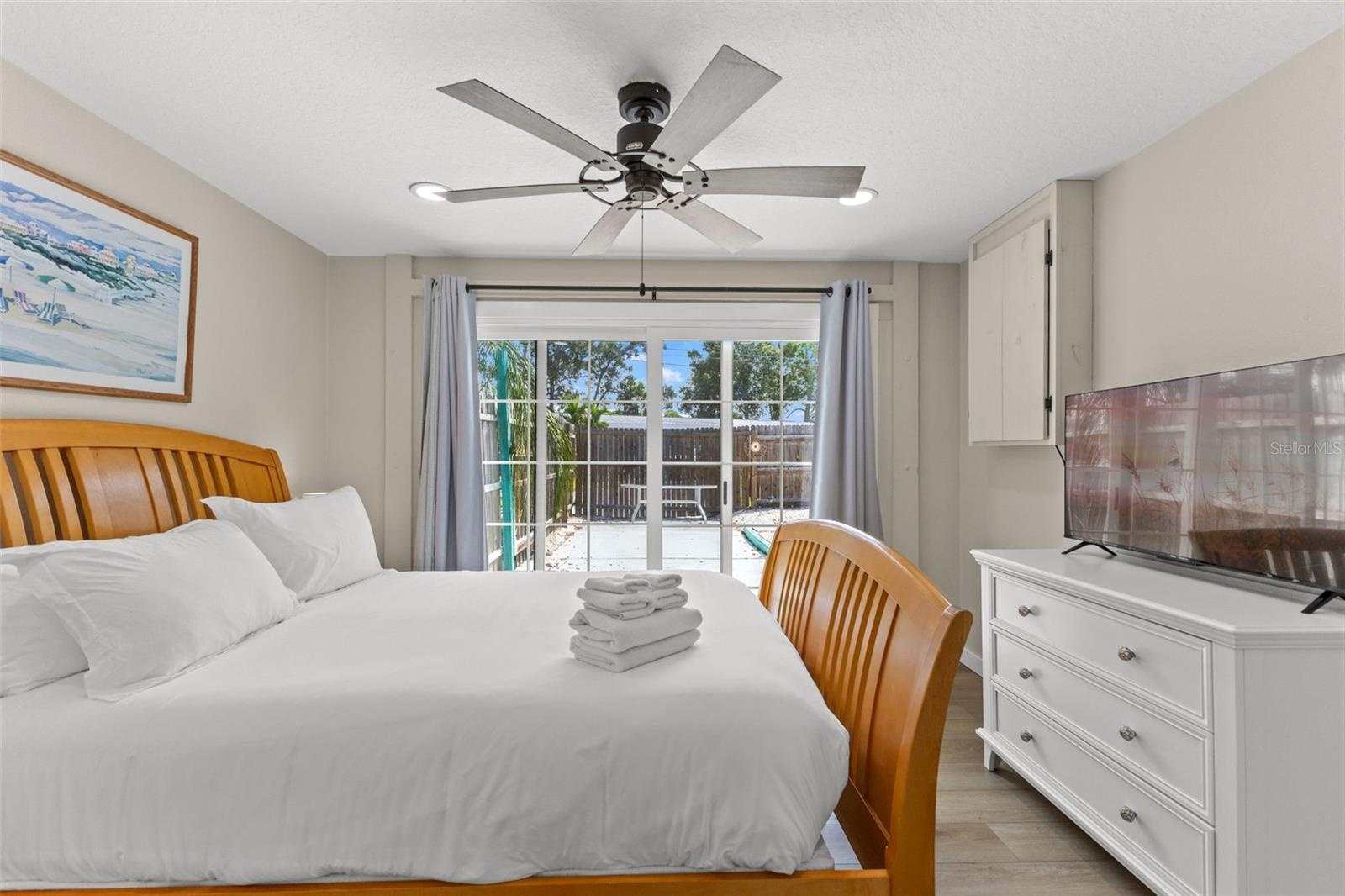 Another view of the owner's bedroom highlights the direct pool access and abundant natural light from the oversized sliding glass doors.