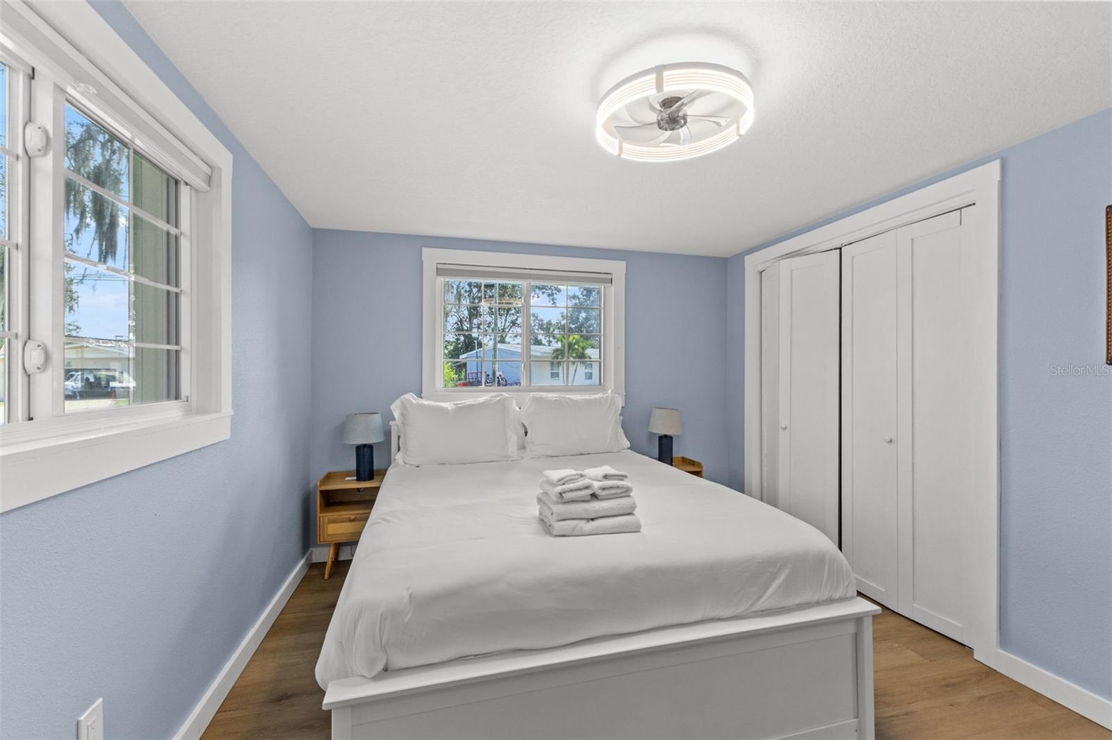 Another view of the bedroom highlights the natural light, closet storage, and no-carpet flooring.