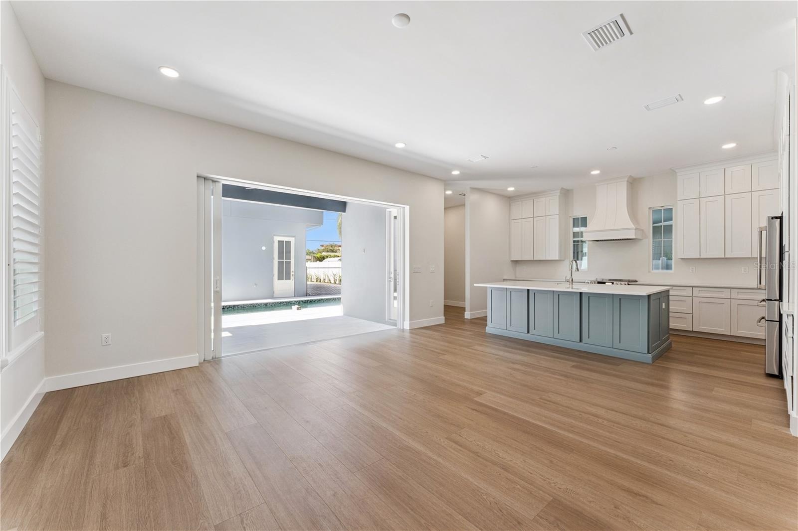 Side sliding glass doors connect the main living area with the covered rear patio.