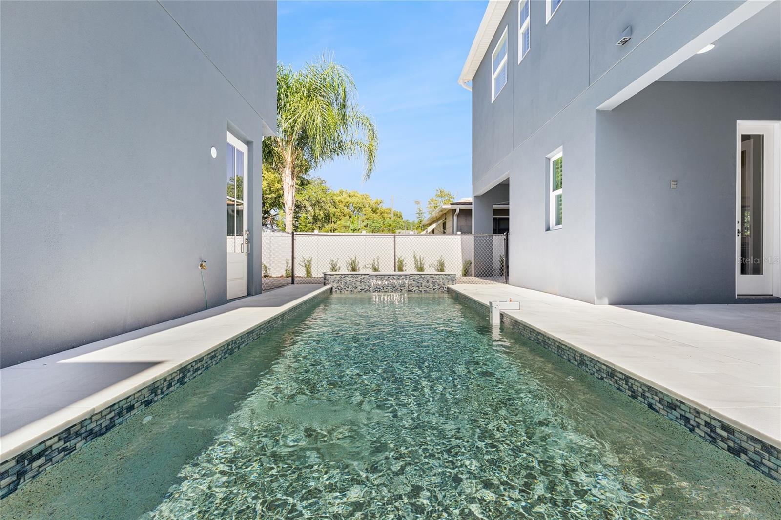 A lengthwise pool view shows the surrounding paved deck and the relationship to the home.