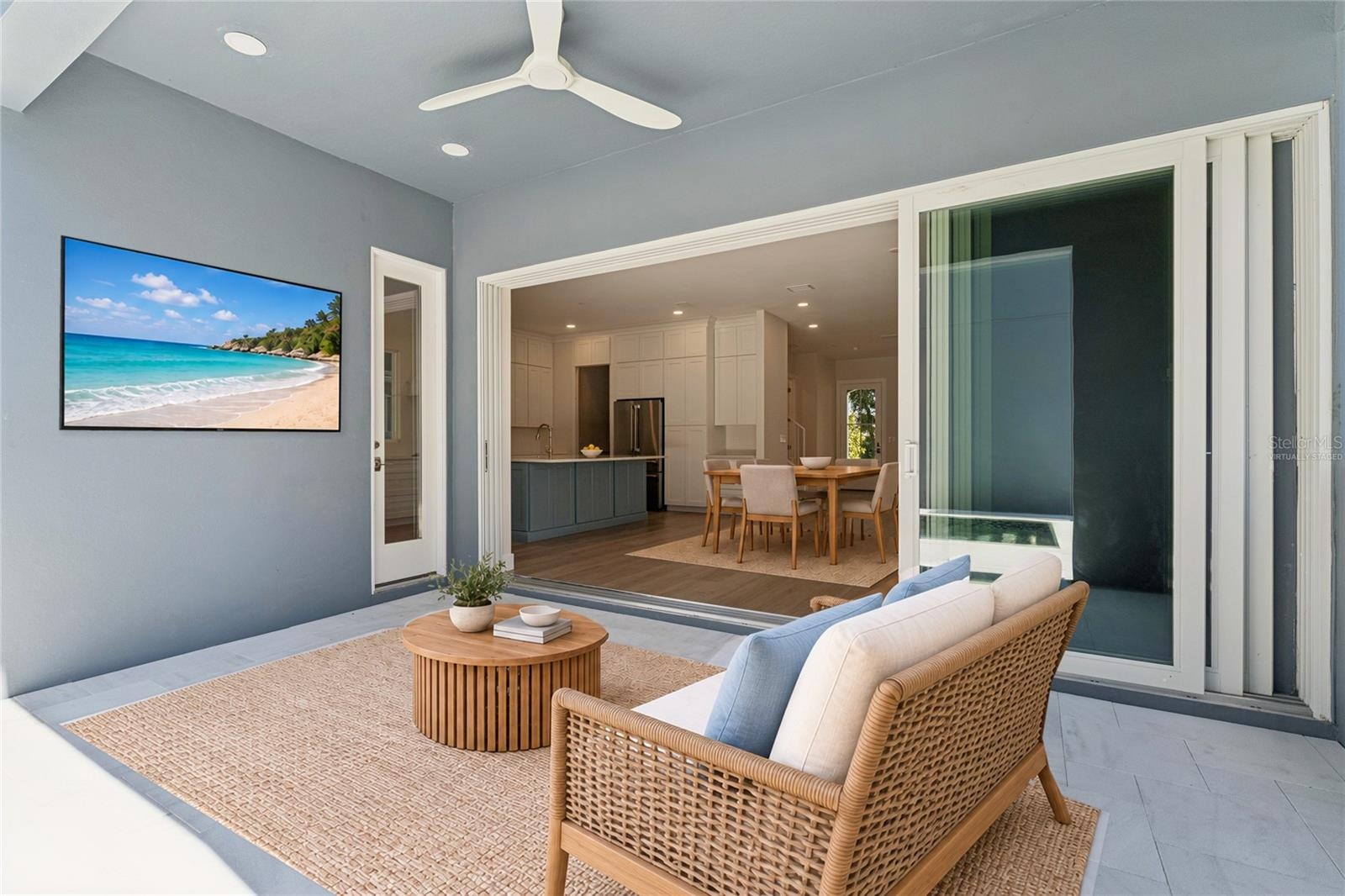 Virtually Staged - The covered rear patio has a ceiling fan and sliding doors to the main living area.