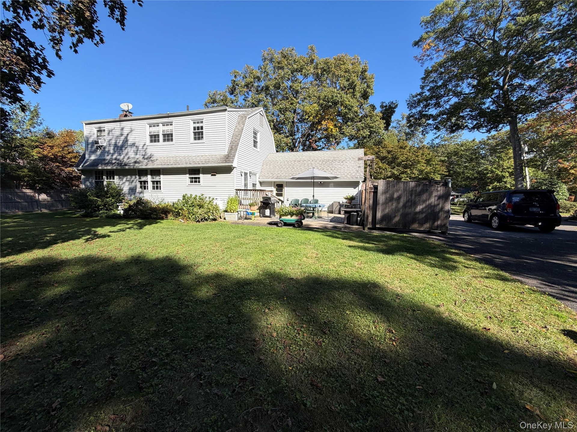 Back of home, partial view of yard,  from driveway