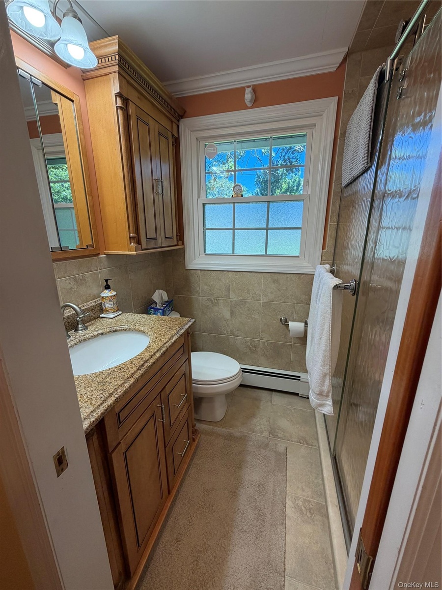 Full bath on main level, walk-in shower,  enclosed with glass doors