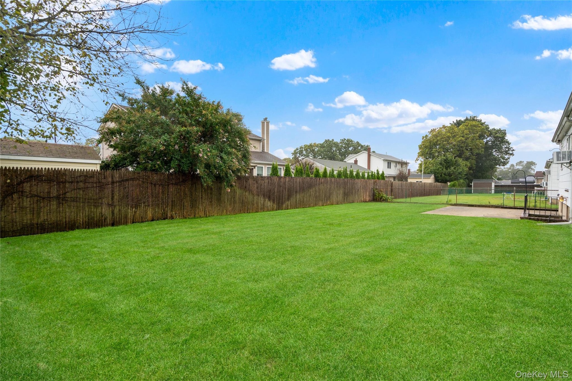 View of the backyard with an established lawn that is professionally landscaped.