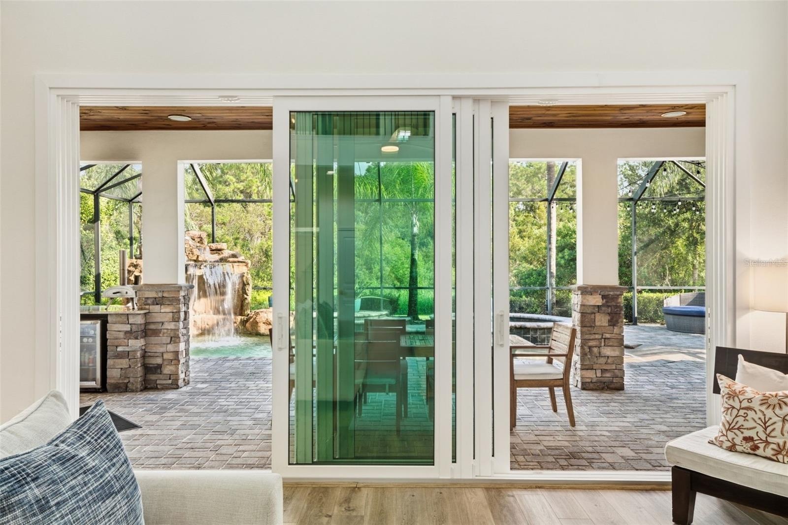 All windows—including this quad slider—are hurricane impact, offering seamless indoor-outdoor living, added peace of mind, energy efficiency, and nois