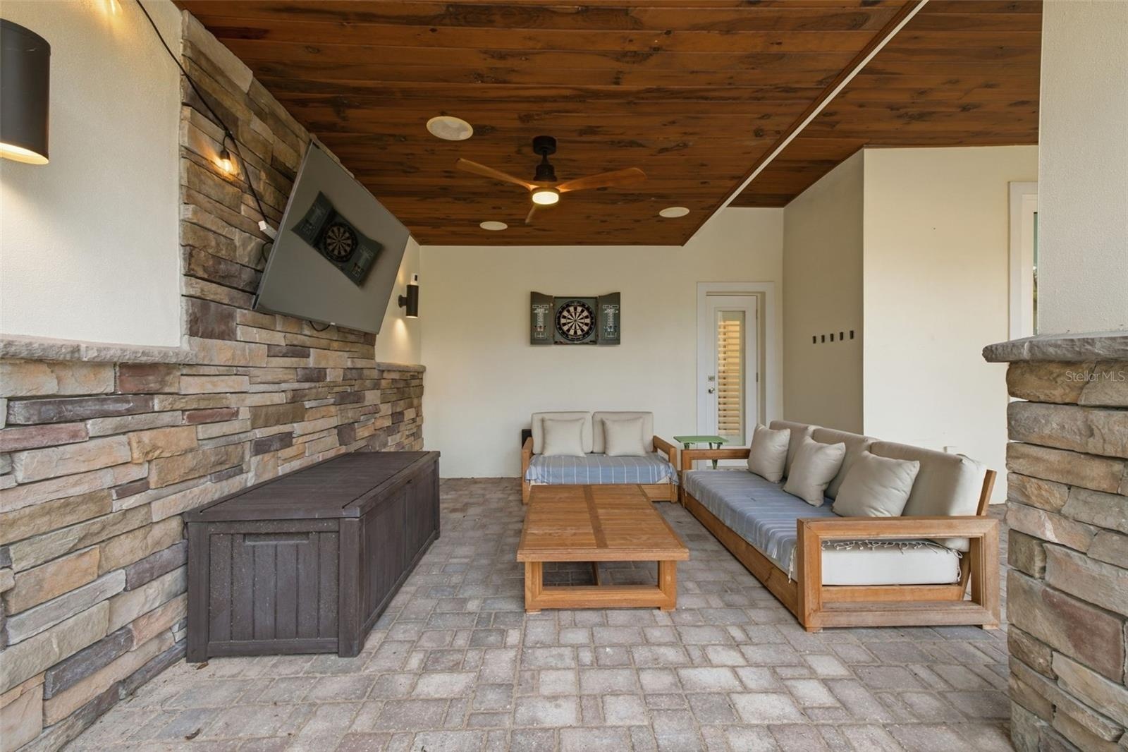 The covered outdoor living area is plumbed for a gas fire pit, and with a wall-mounted TV, it’s ready for fall football and year-round entertaining.
