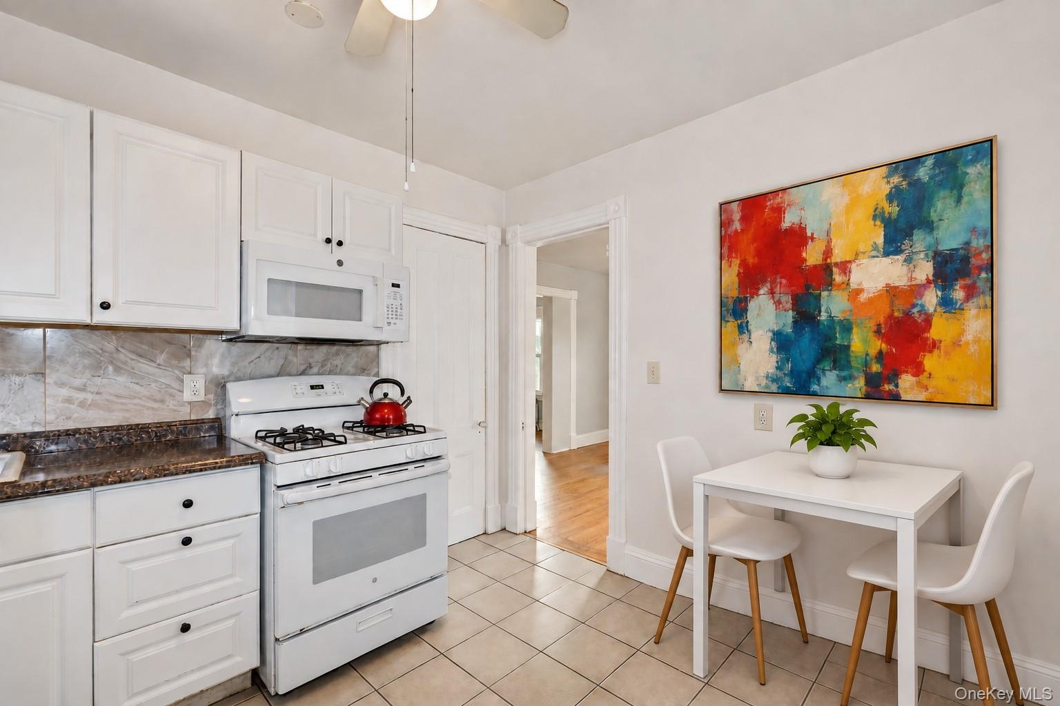 Kitchen with white appliances, gas stove and refrigerator. Enhanced with virutal staging.