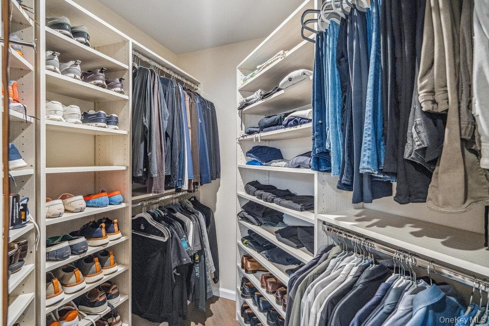 Custom closet organization system with multiple shelving units and hanging rods