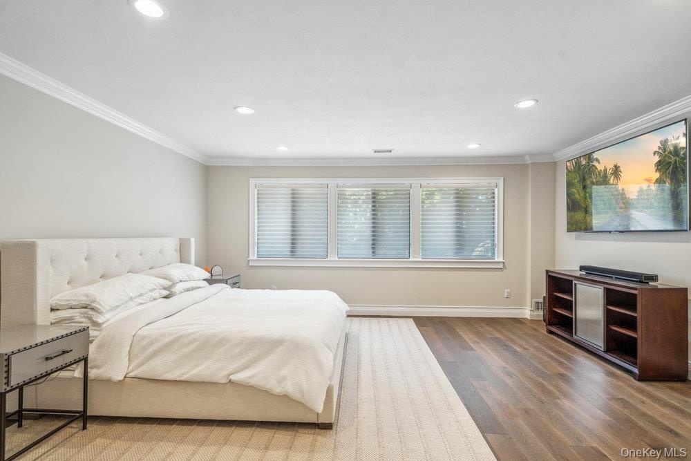 Recessed lighting, crown molding, wood-finish flooring, and multiple windows with blinds