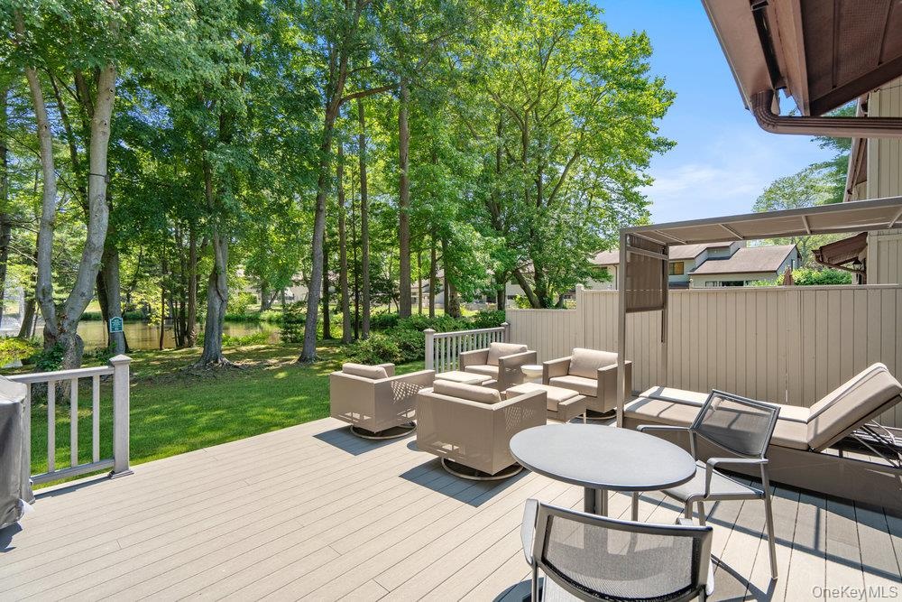 Spacious outdoor deck with composite decking, white railing, and a slatted privacy wall