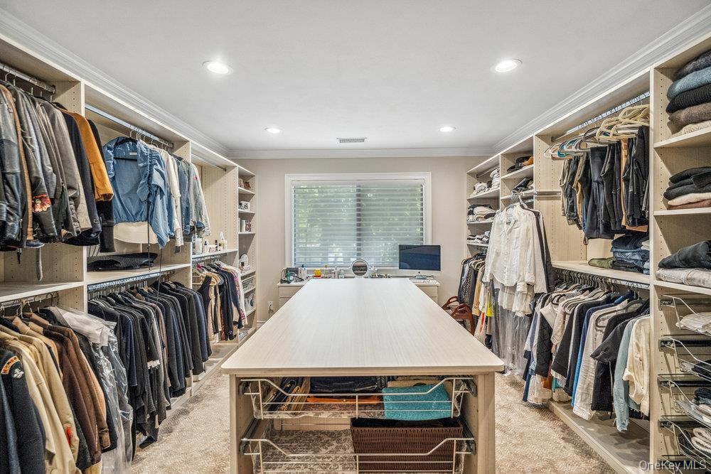 Custom closet system featuring extensive shelving, hanging rods, and pull-out drawers