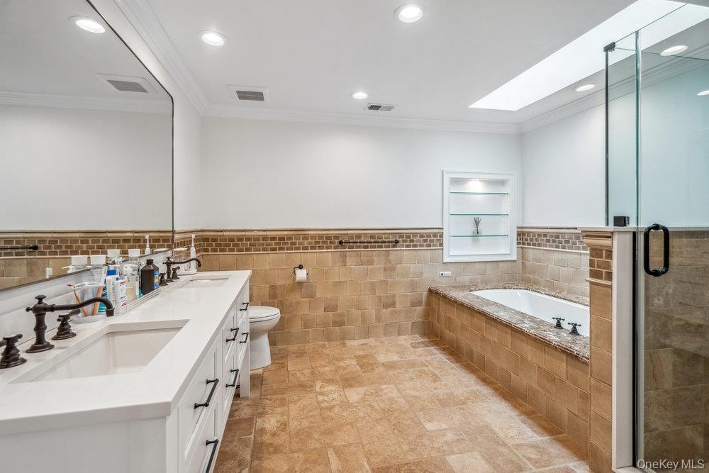 Dual vanity with white cabinetry and dark hardware, set against a full-width mirror