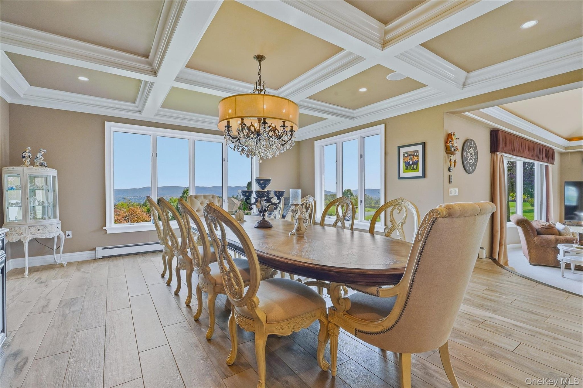 Coffer-style ceiling with recessed lighting, large picture windows, and a chandelier
