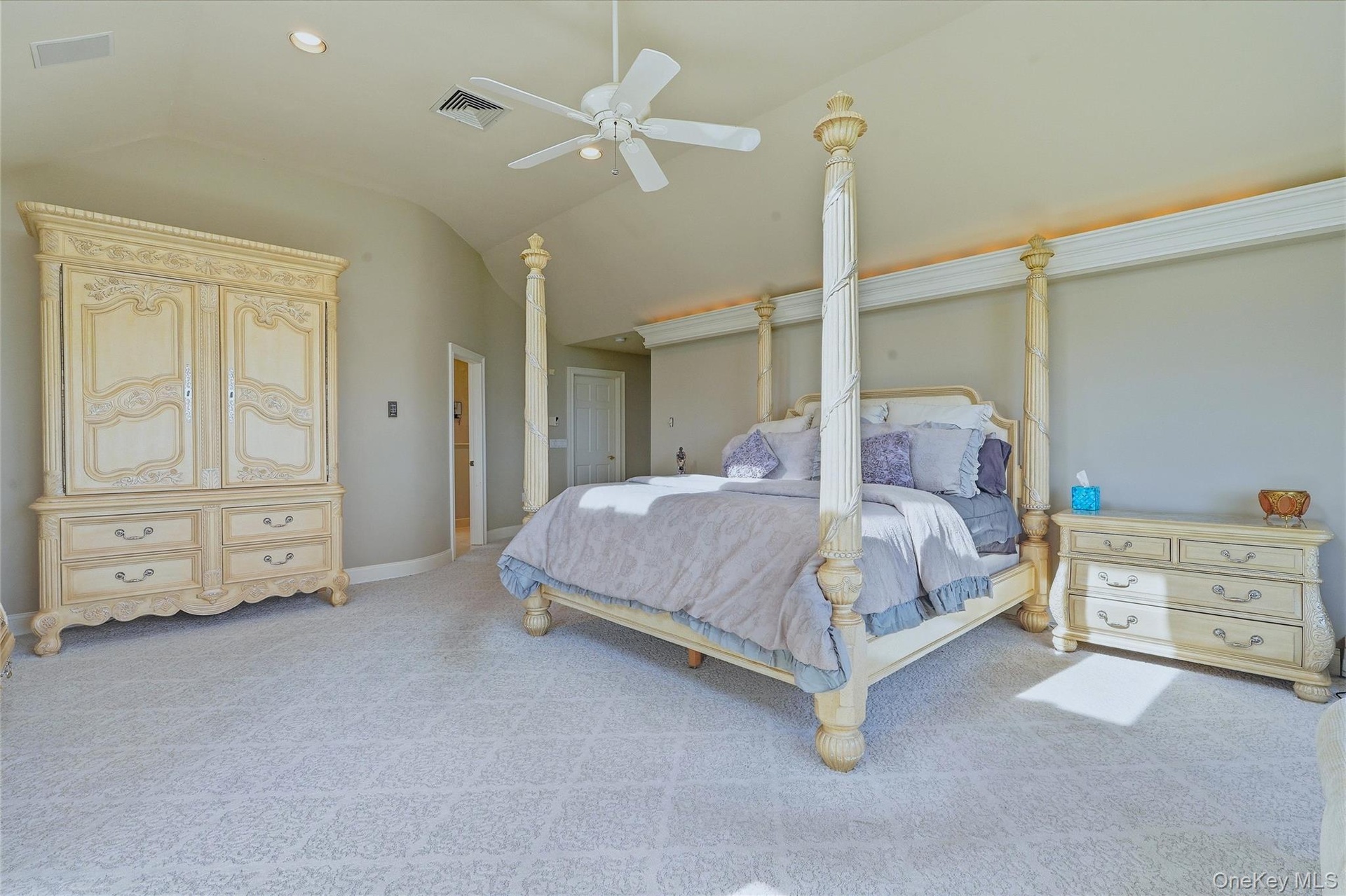 Vaulted ceiling with a ceiling fan, recessed lighting,  complemented by carpet flooring
