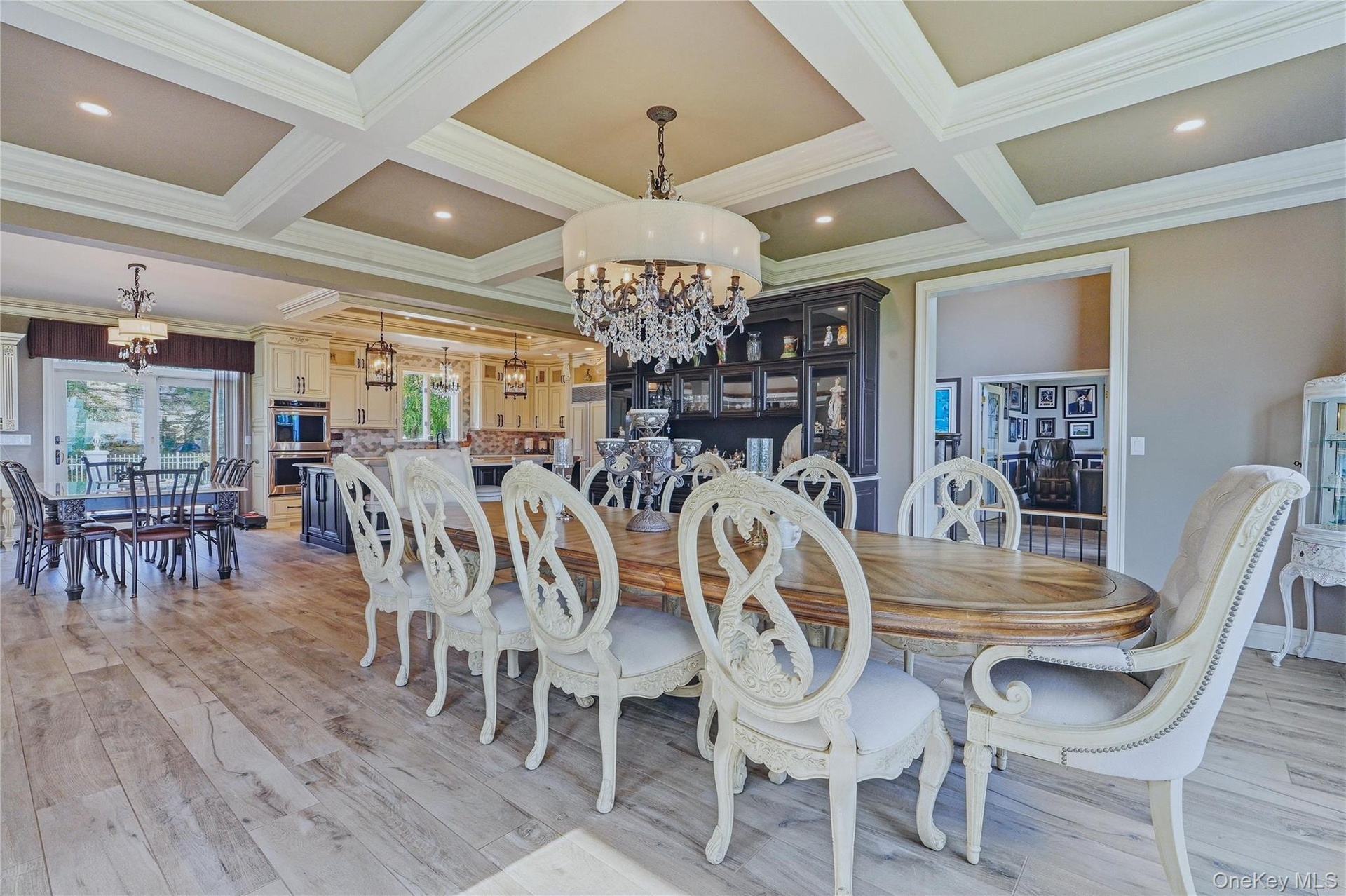 Coffered ceiling, chandelier lighting, built-in display cabinetry, and sliding glass door