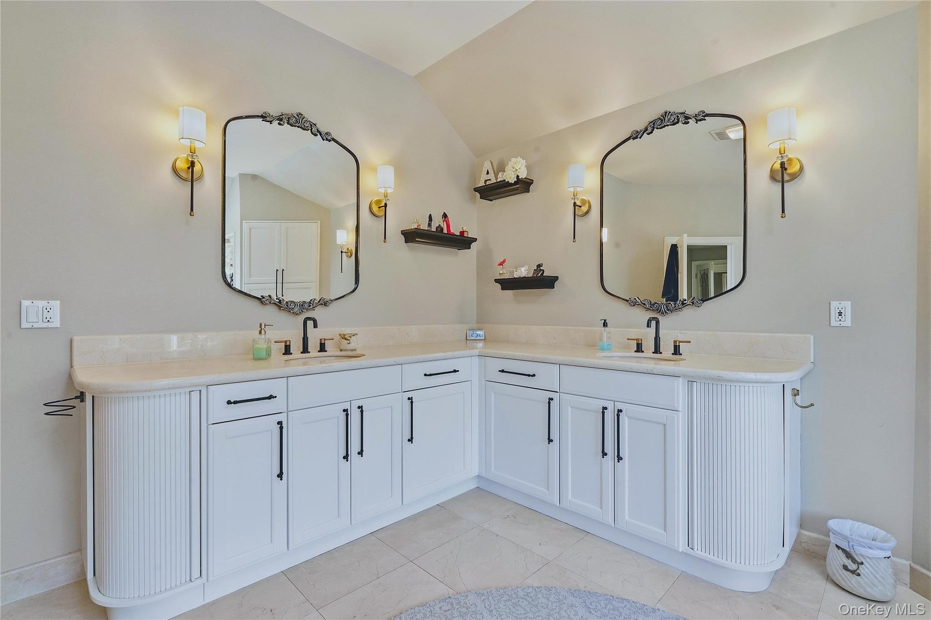 Dual vanity with white cabinetry and black hardware, marble flooring