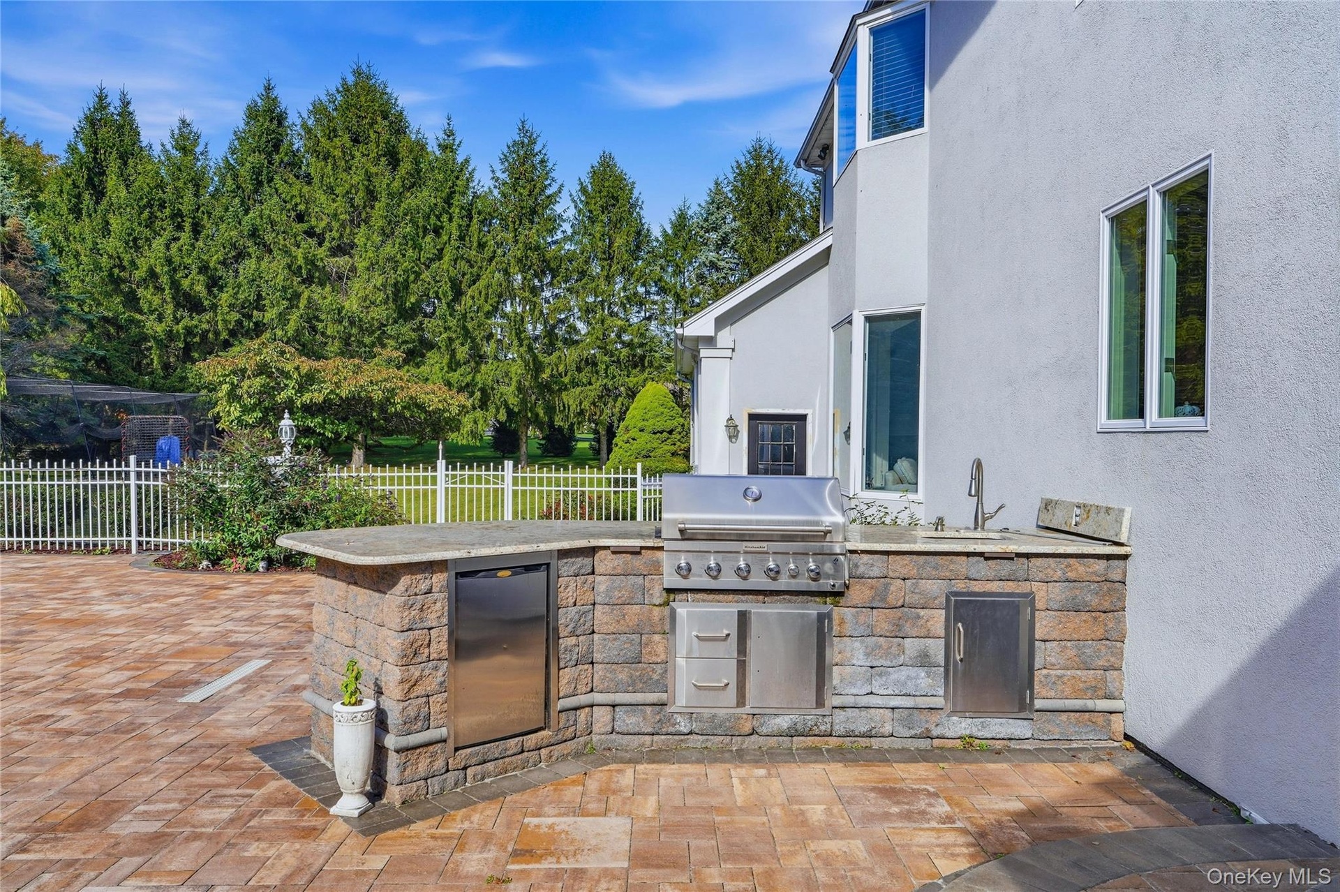 Outdoor kitchen featuring a built-in grill, sink