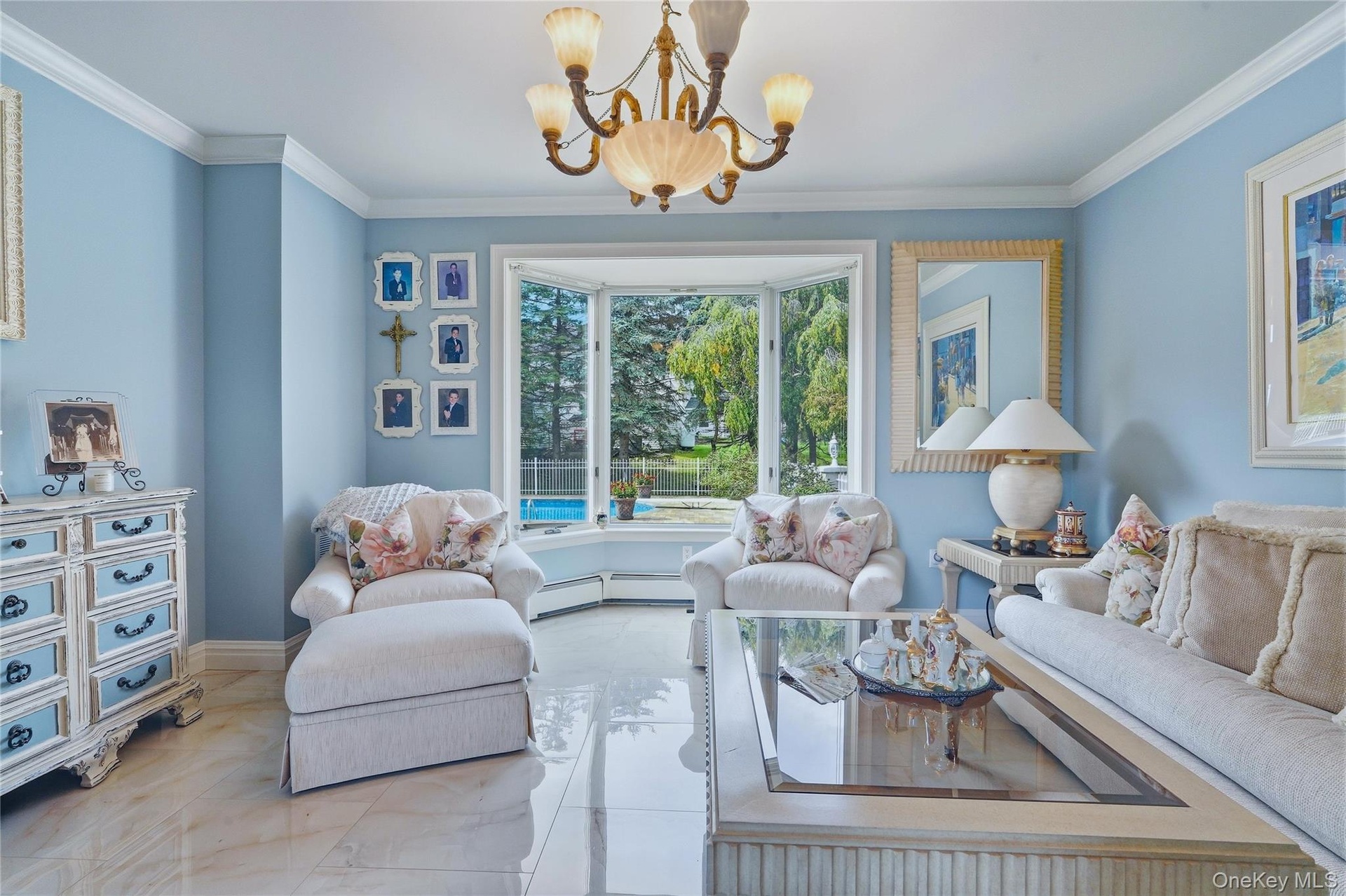 Bay window with a pool view, crown molding, chandelier, and polished tile flooring