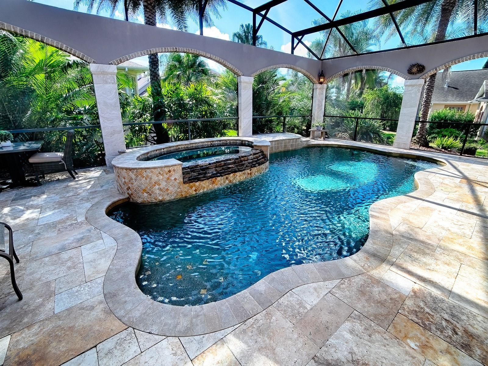 BEAUTIFUL SALT WATER POOL AND SPA SURROUNDED BY STONE COLUMNS AND TROPICAL LANDSCAPING FOR COMPLETE PRIVACY.