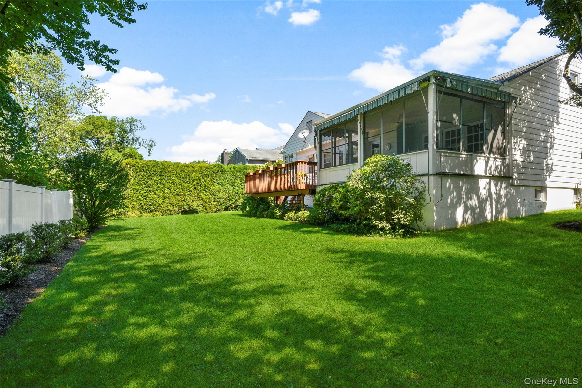 Private level yard with soft green grass and plantings