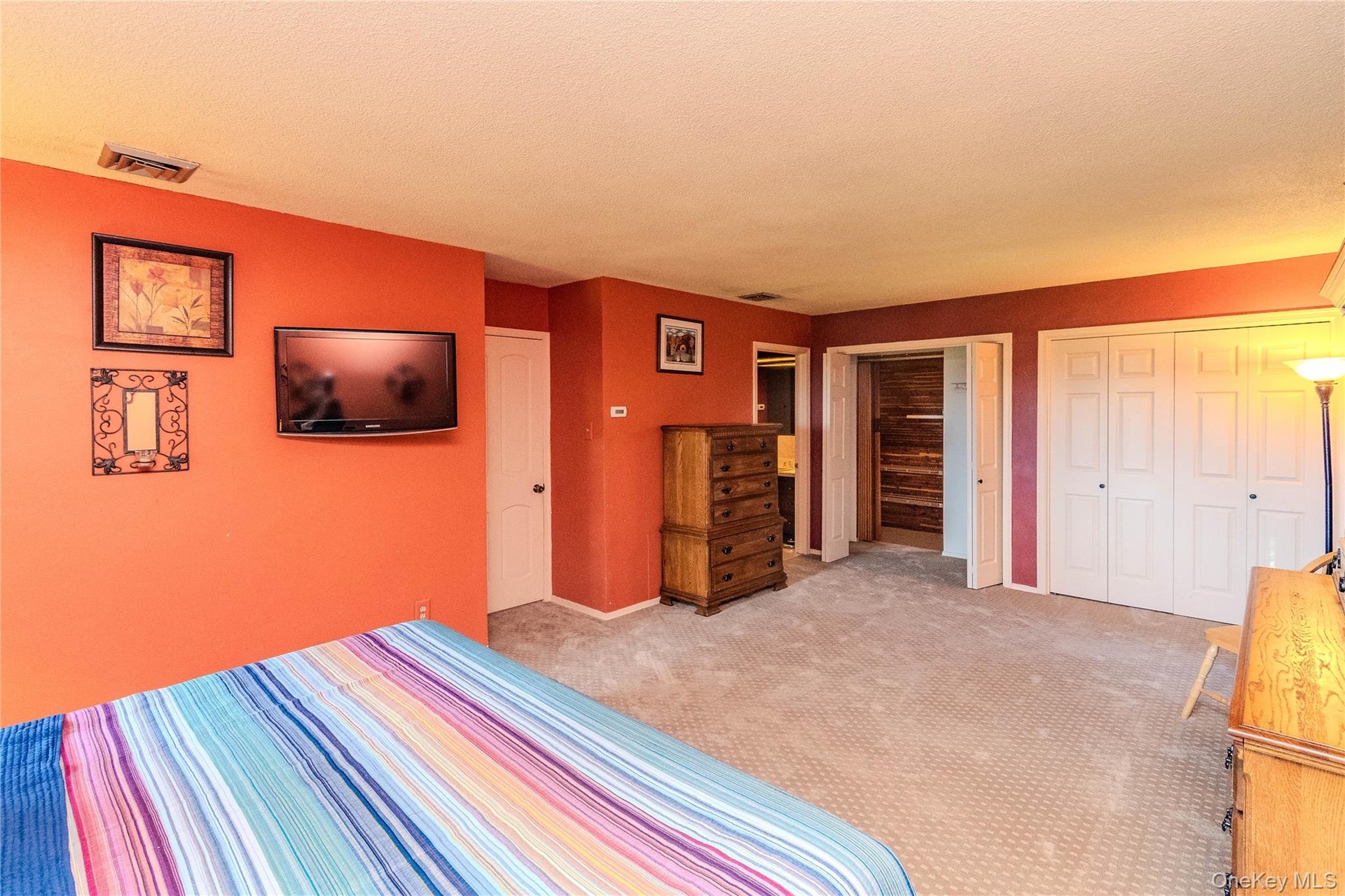 Carpeted flooring throughout, white interior doors, and a closet with bi-fold doors