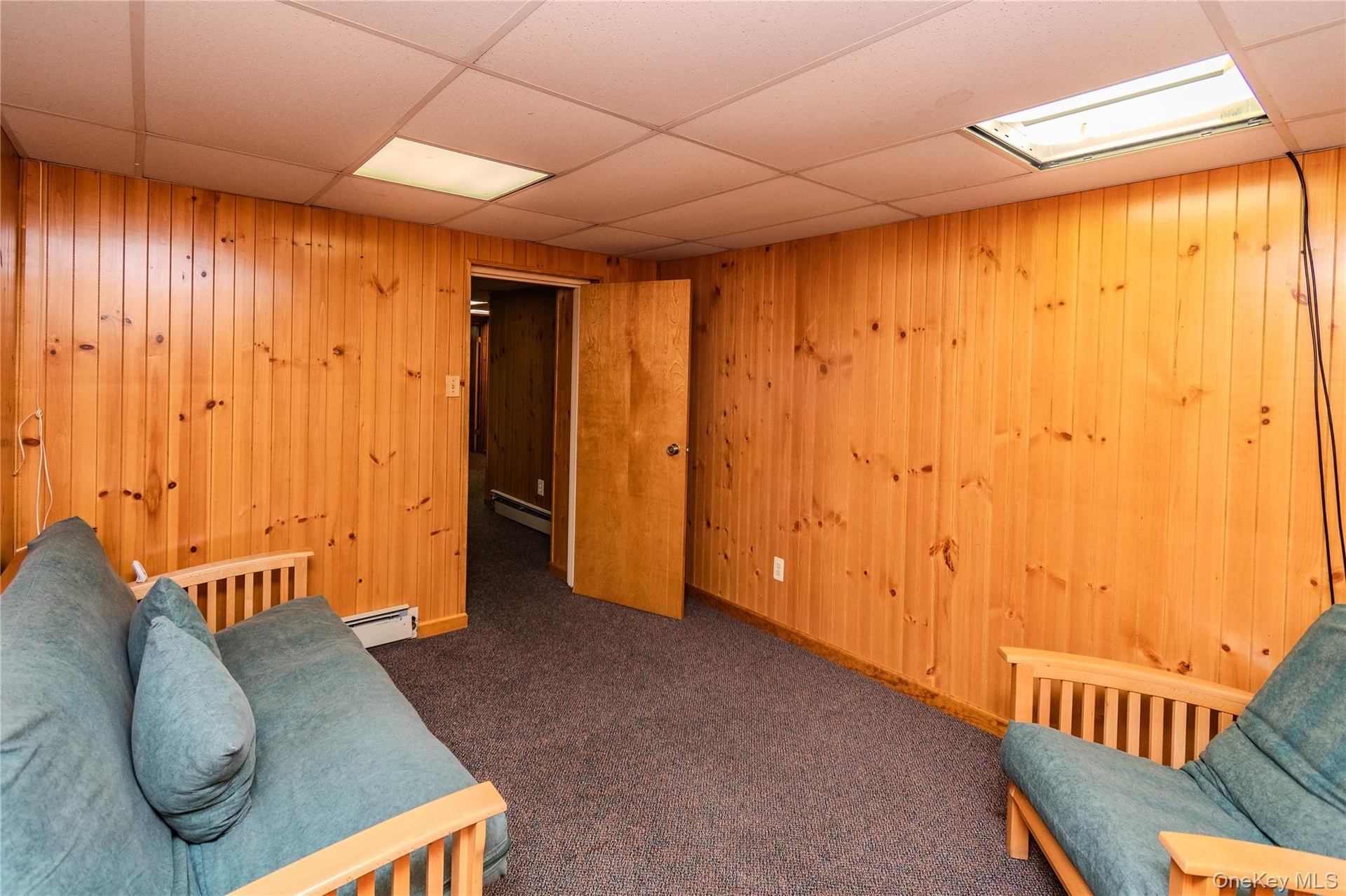 Wood paneling accentuates the walls, complemented by a drop ceiling with integrated lighting