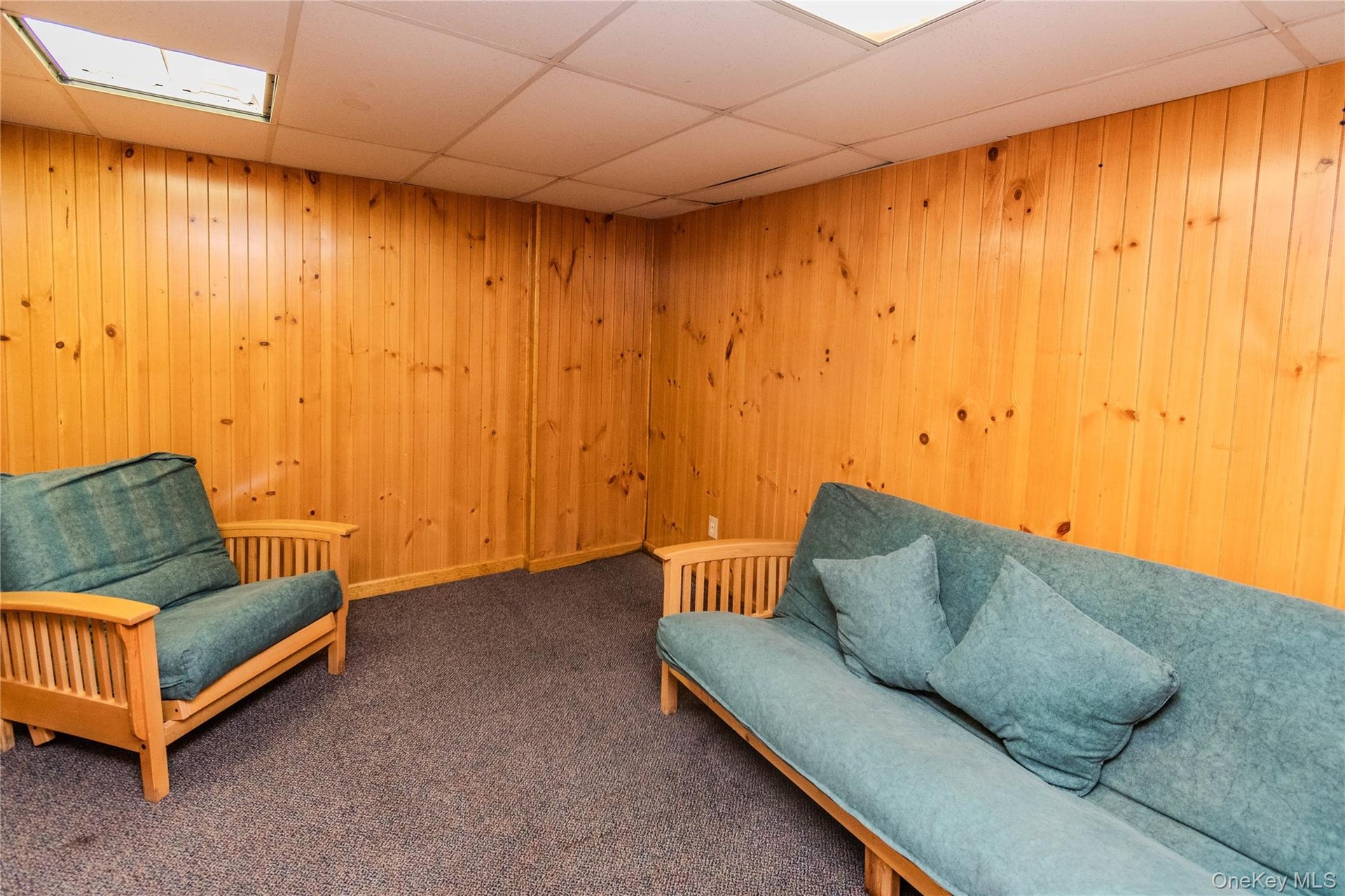 Wood-paneled walls with a drop ceiling and recessed lighting