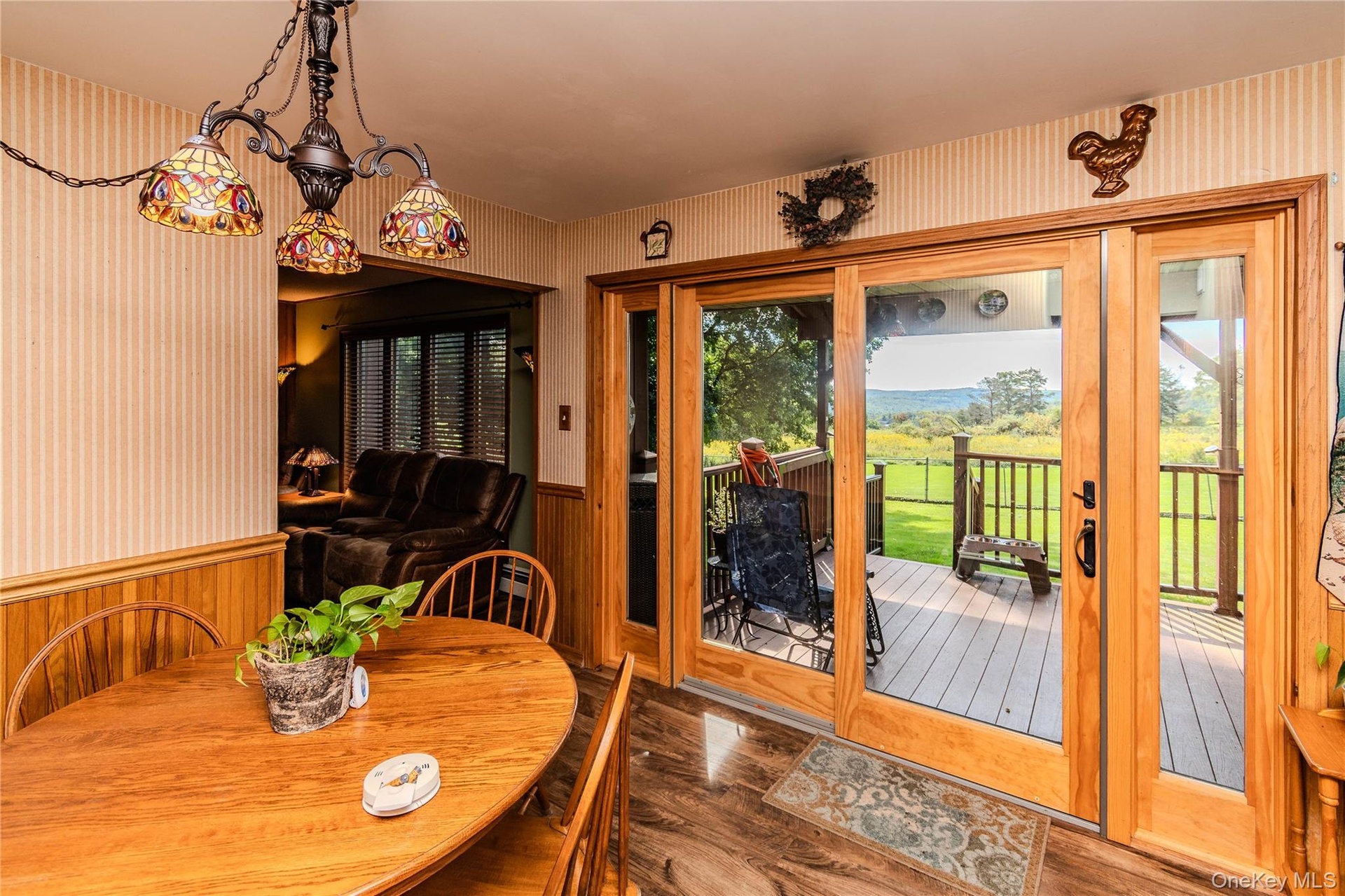 Wood-finish flooring, half-wall wainscoting, and patterned wallpaper