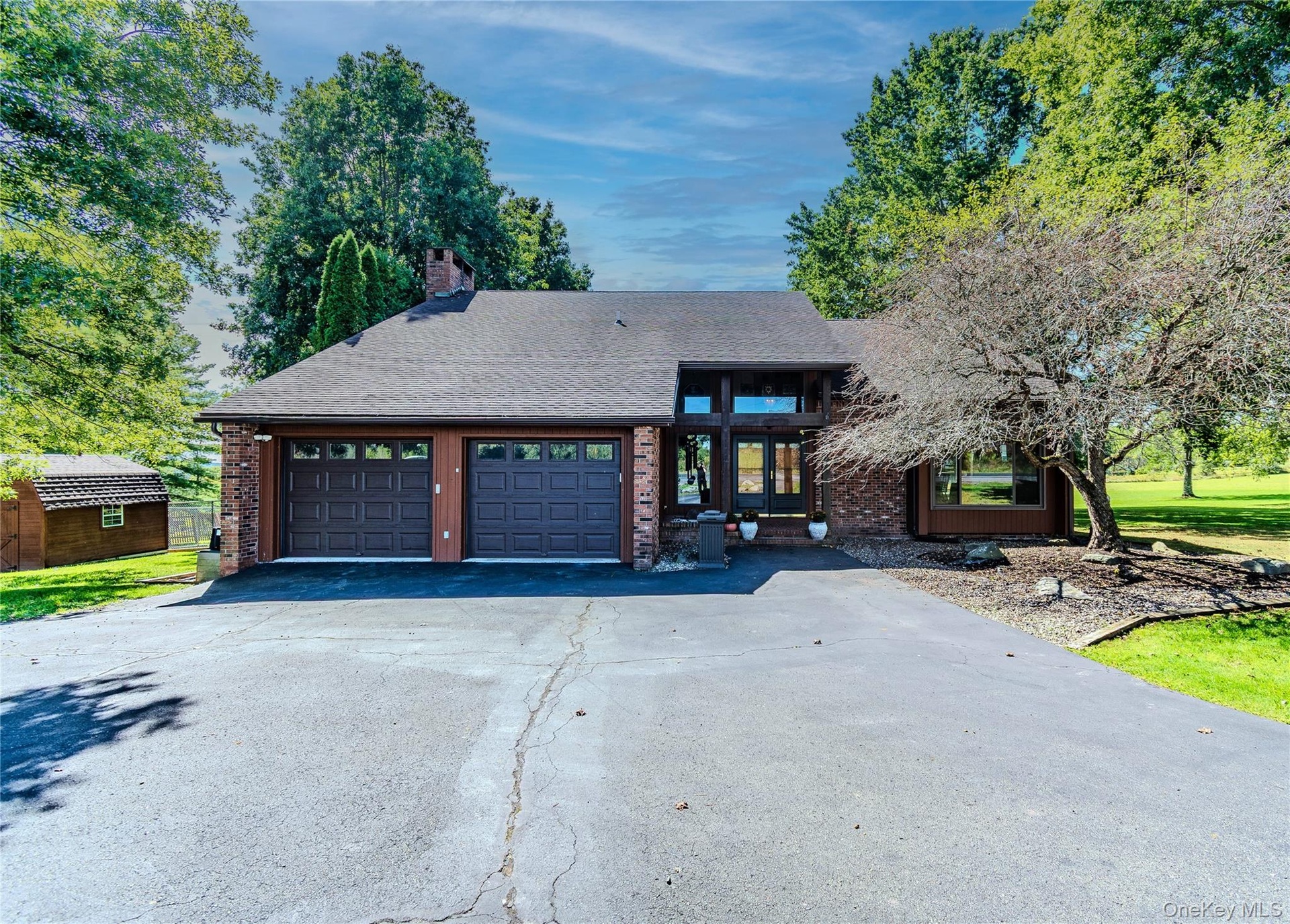 Brick facade with dual attached garage featuring panel doors and window inserts