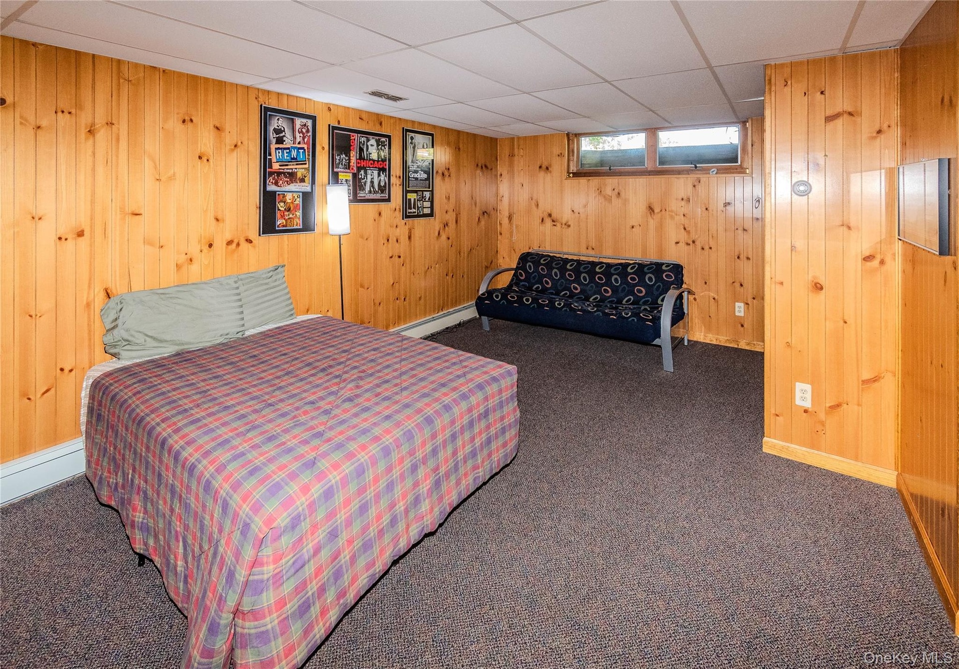 Wood-paneled walls with carpet flooring and a drop ceiling
