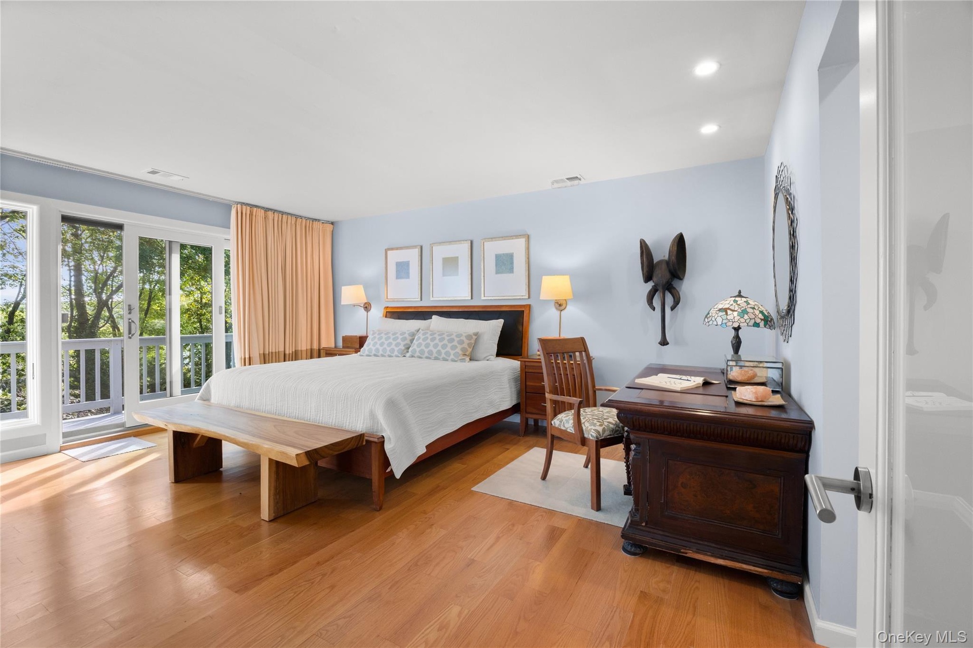 Primary bedroom with sliding glass doors leading to second story deck with winter waterviews